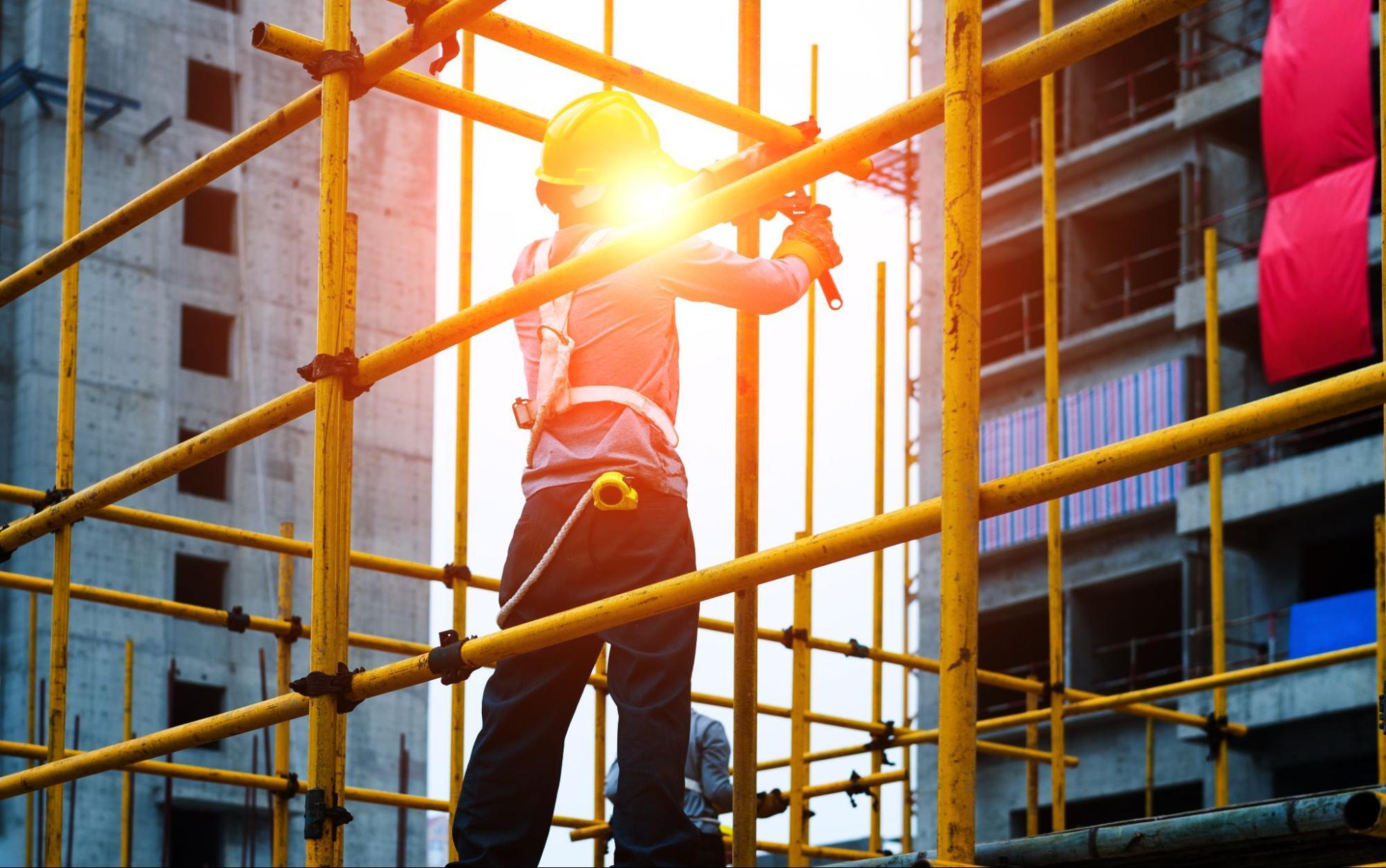 An employee of a scaffolding company, setting up scaffolding