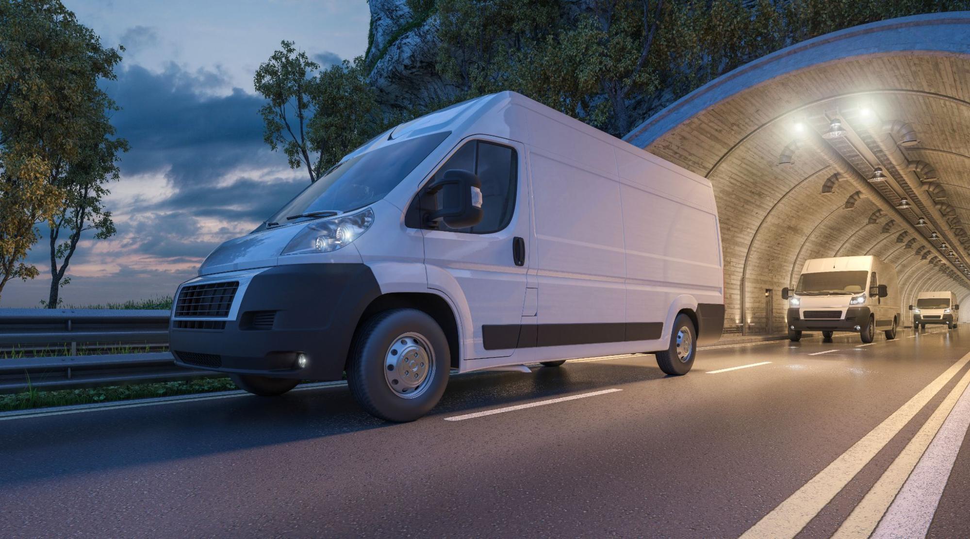 Commercial vans that are covered by fleet insurance driving out of a tunnel